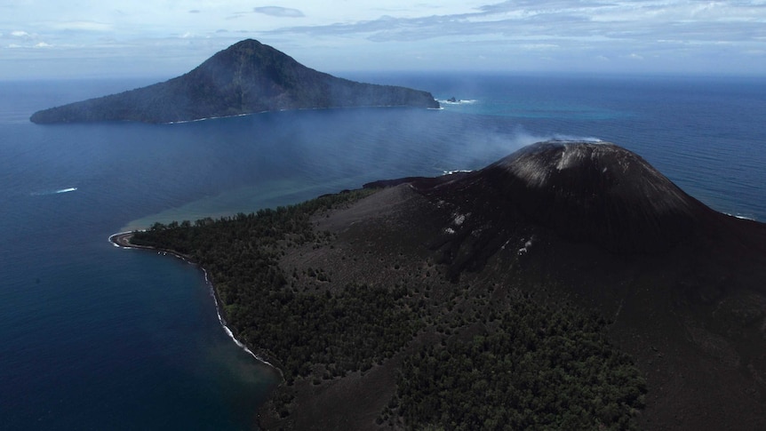 A boat travels between two islands, one with a smoking volcano towering over the coastline.