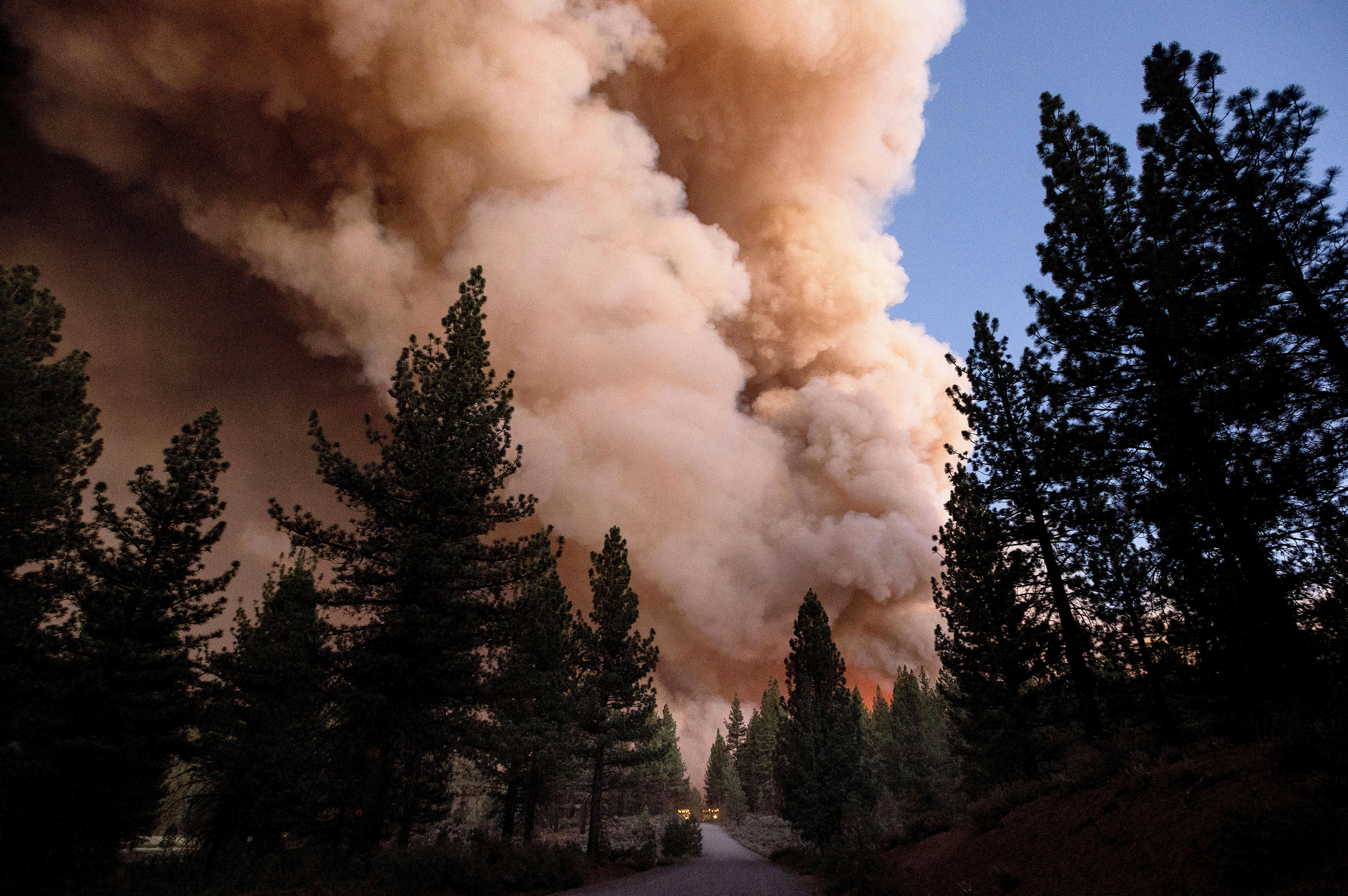 Rauch- und Feuerwolken steigen über einer Straße auf