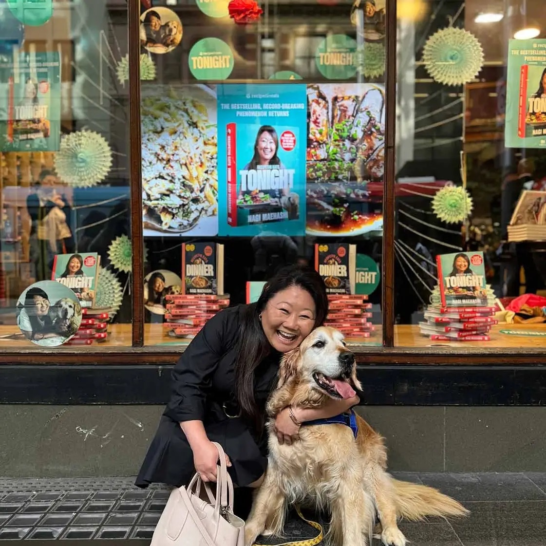 Nagi Maehashi posa con su golden retriever Dozer frente al escaparate de una librería.