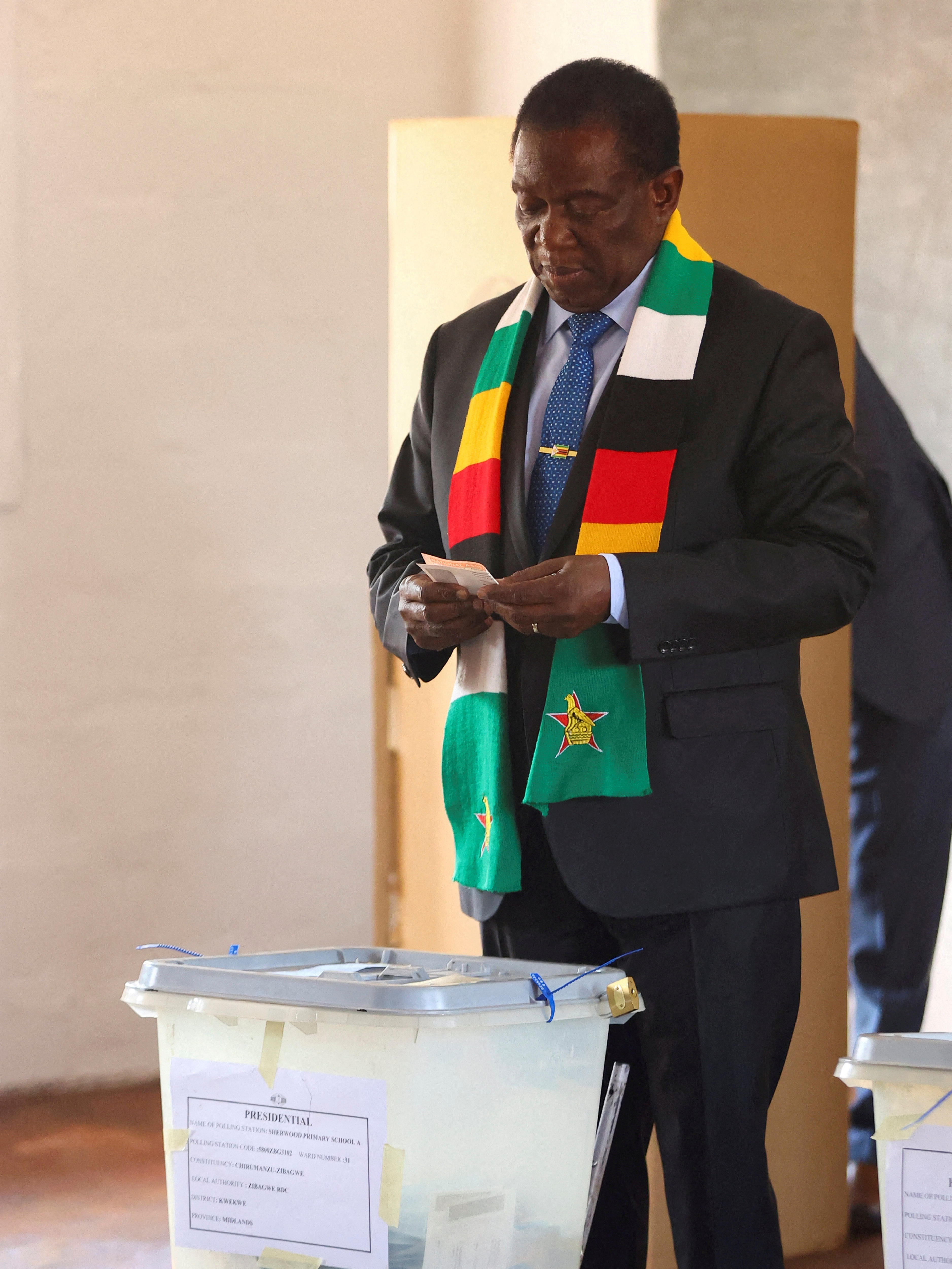 Man in checkered scarf casts vote 