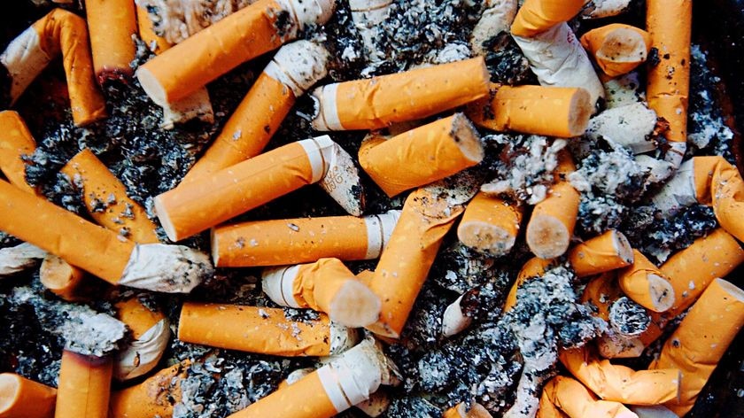 A smoker's ashtray filled with cigarette butts and ash
