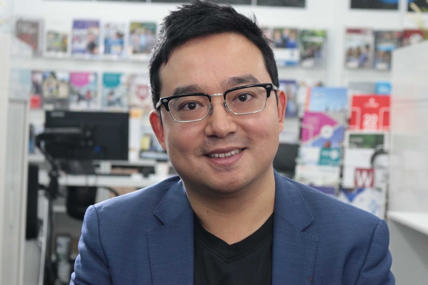 Sean Dong smiles as he looks down the barrel of the camera for a head and shoulders picture.