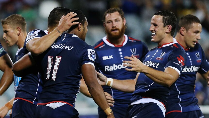 Try time ... Sefanaia Naivalu is congratulated after scoring for the Rebels