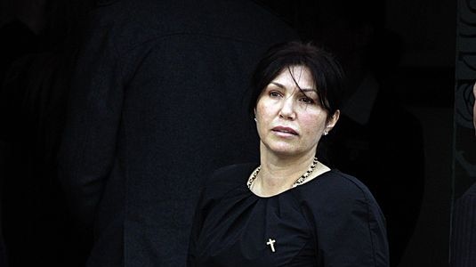 Roberta Williams dressed in black stares into the camera lense at the funeral of Carl Williams