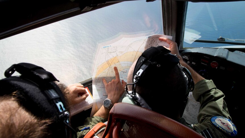 Pilot examines map on board RAAF P3 Orion