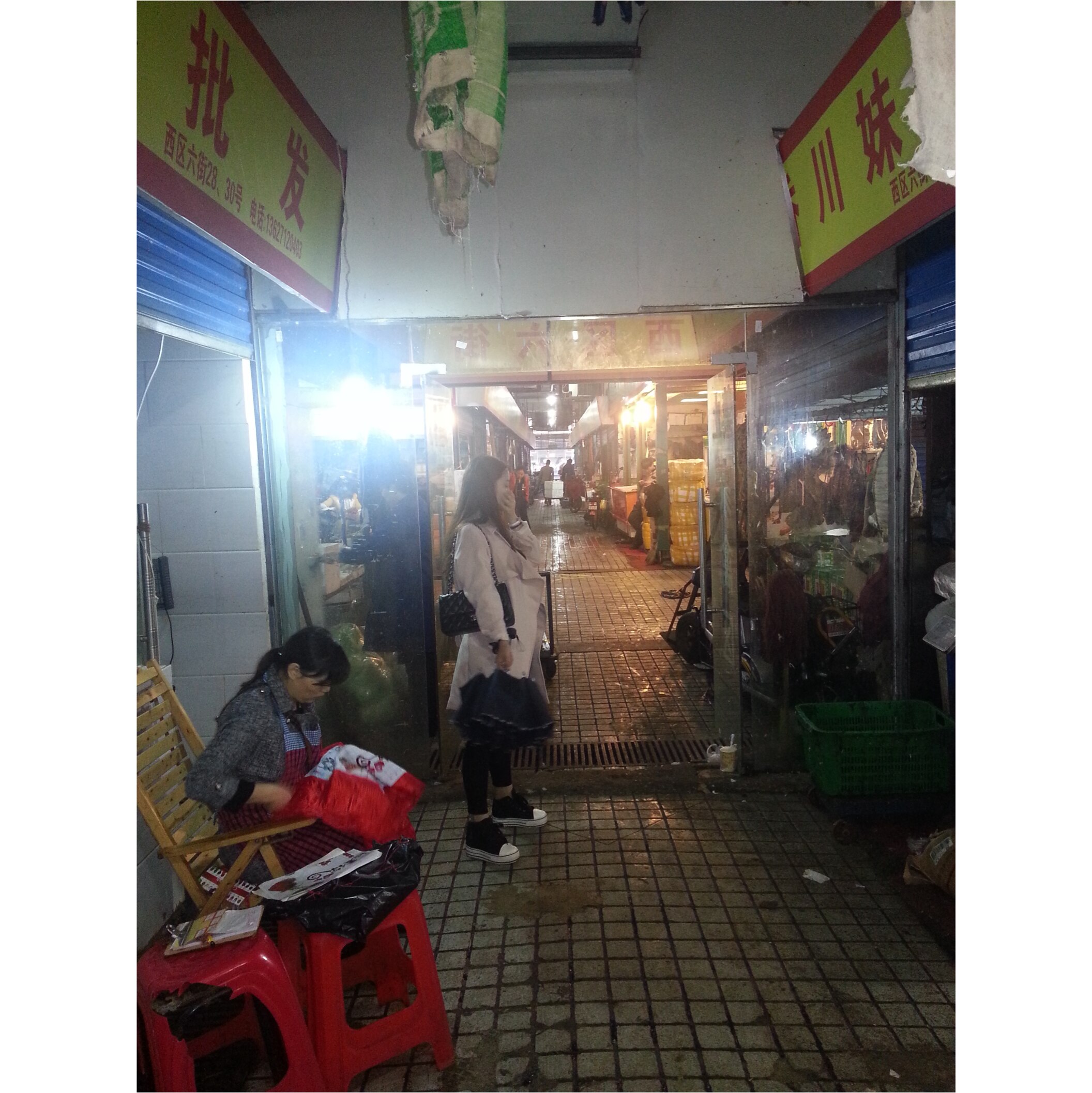 Dark and dirty entrance to a market with signs in Chinese.