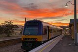 A country link train arrives at Tarana station at sunset