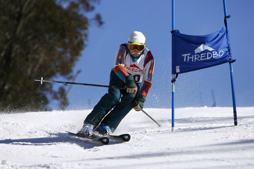An elderly man skis downhill 