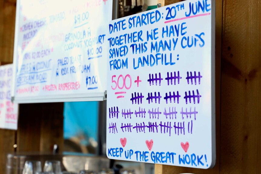 A whiteboard with a tally about how many cups have been saved from landfill