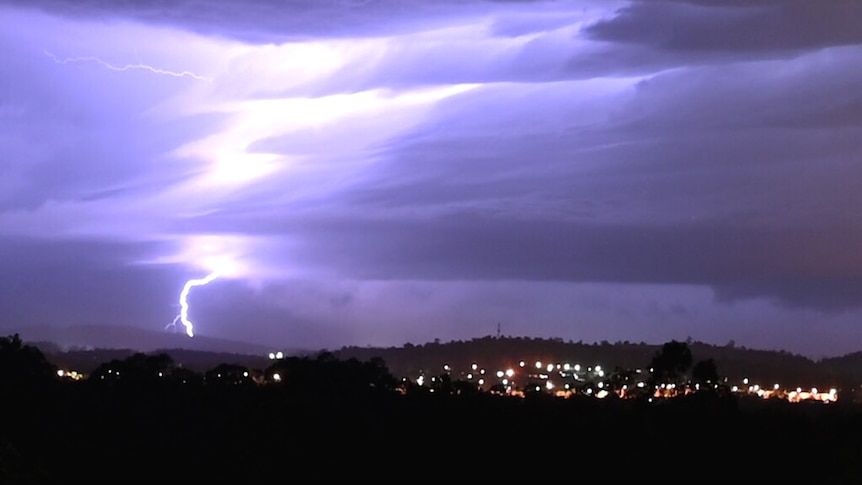 Lightning in the distance over suburban lights at night