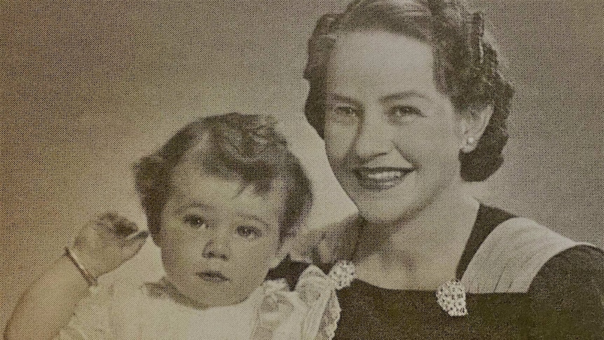 A small toddler and mother pose in black and white photo