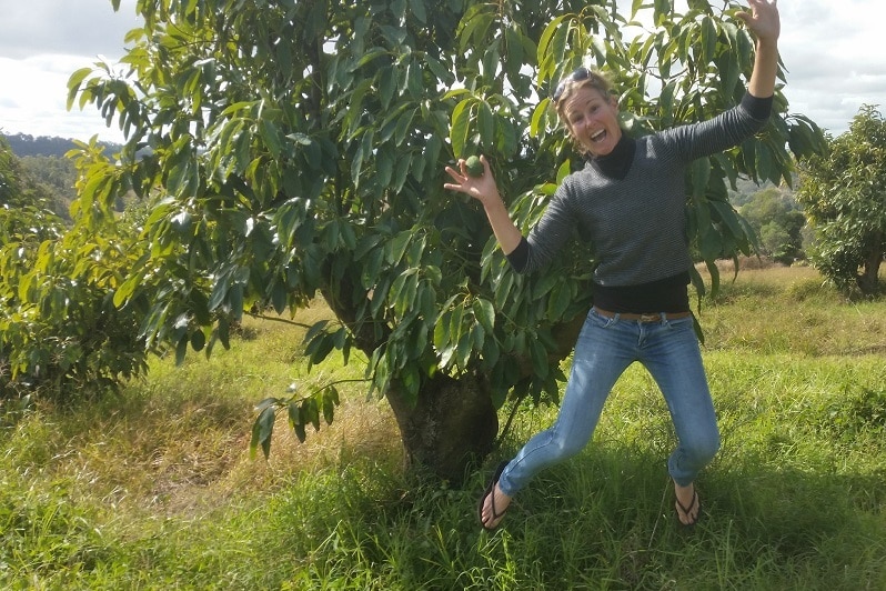 Kate Groves jumping for joy on her avocado farm.