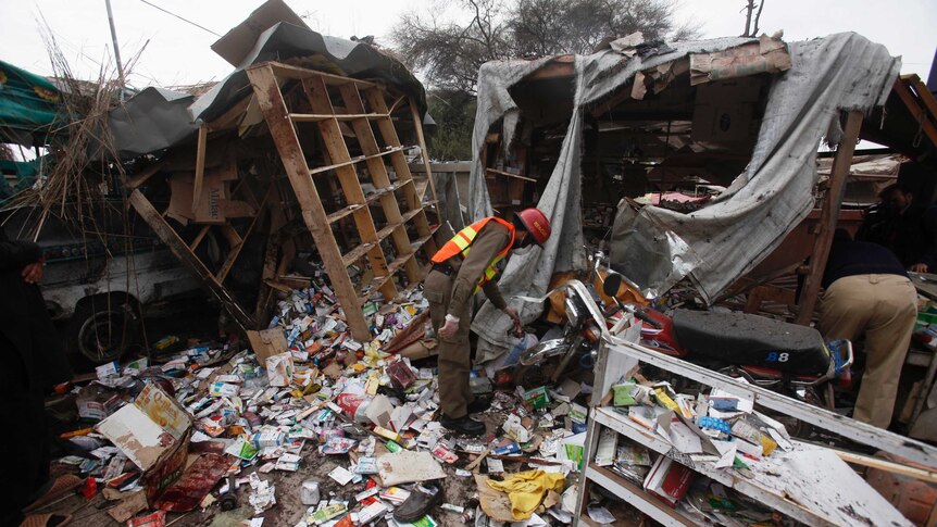 A rescue worker collects evidence at the site of a bomb blast