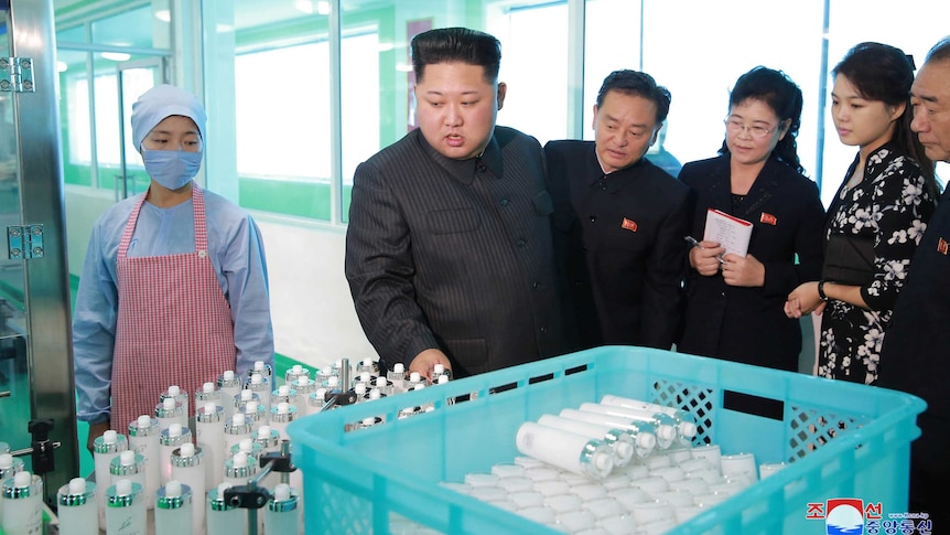 North Korean leader Kim Jong Un and wife Ri Sol Ju examine cosmetics at a factory.