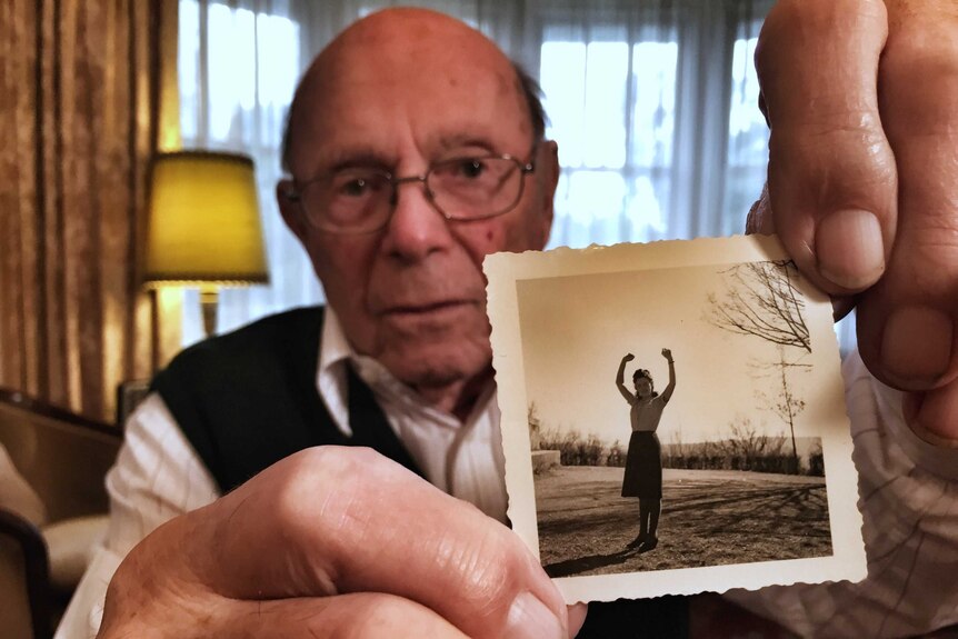 Phillip Maisel holds up an old photo of his twin sister Bella Hirshorn.
