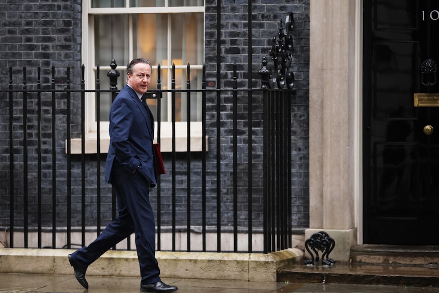 David Cameron walks outside of 10 Downing Street. 