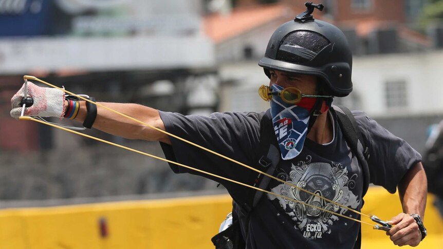 A protester prepares to fire a slingshot in Caracas