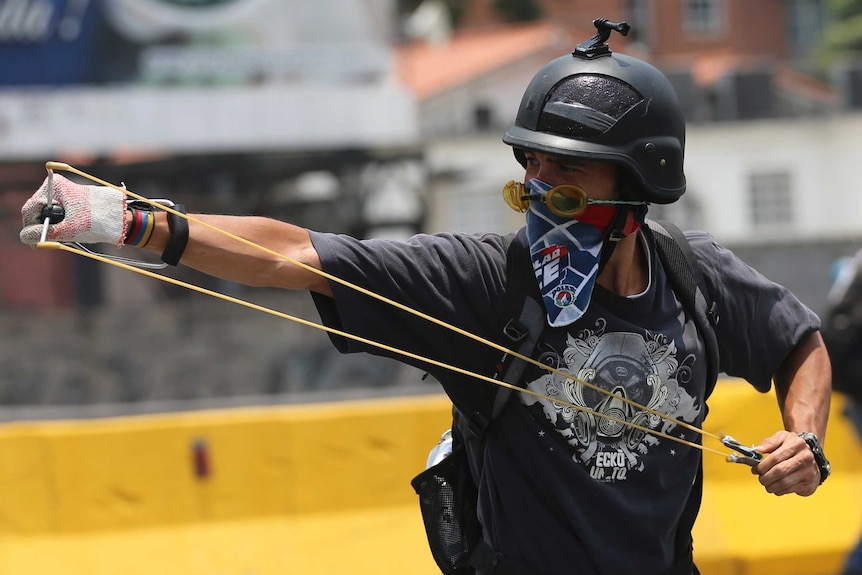 A protester prepares to fire a slingshot in Caracas
