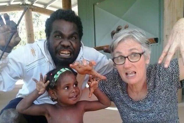 Woman pulls a scary face with indigenous man and young child