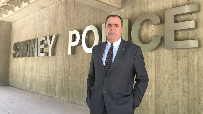 Deputy Commissioner Nick Kaldas standing in front of a large Sydney Police sign.