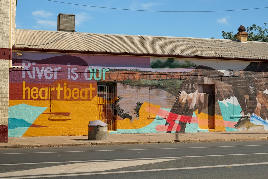 A brightly coloured mural on the side of a building at Wilcannia reads River is our heartbeat