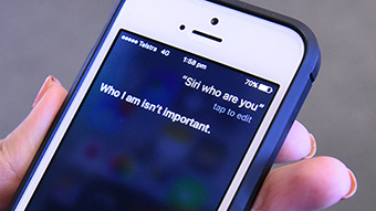 A close up of an iphone. The screen reads: Siri who are you? Siri's response: It's not important.
