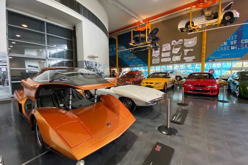 Holden vehicles displayed in a show room at the National Motor Museum in Birdswood, including two suspended under the ceiling.