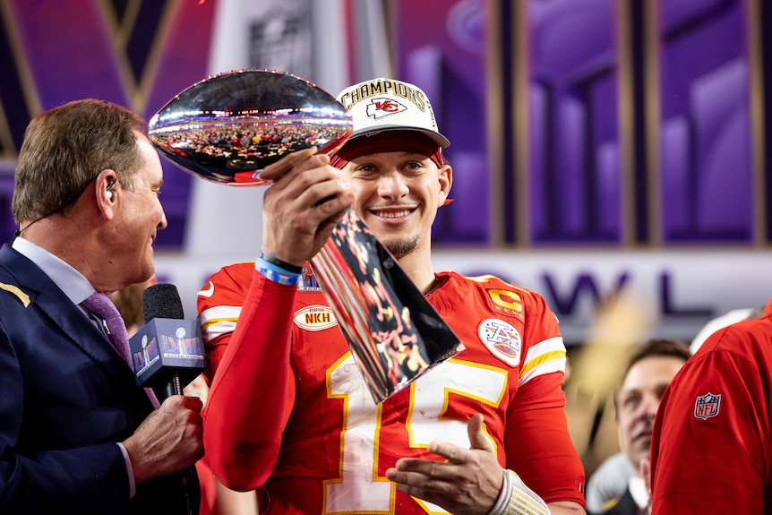 Pat Mahomes smiles and holds the Vince Lombardi trophy