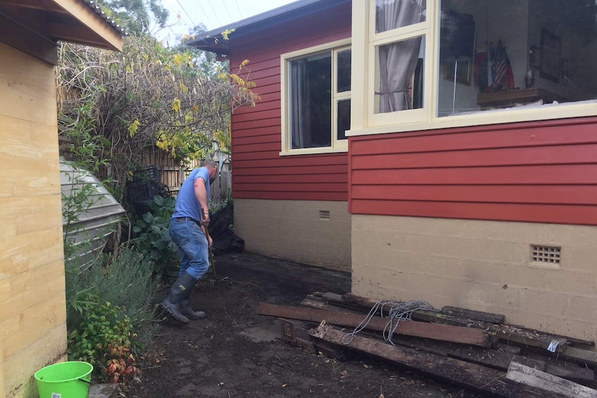 Michael Kerr cleaning his yard after floods.