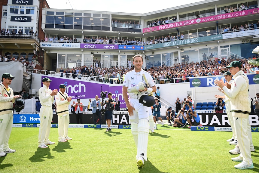 England's Stuart Broad walks through a guard of honour from Australian players in the fifth Ashes Test at The Oval.