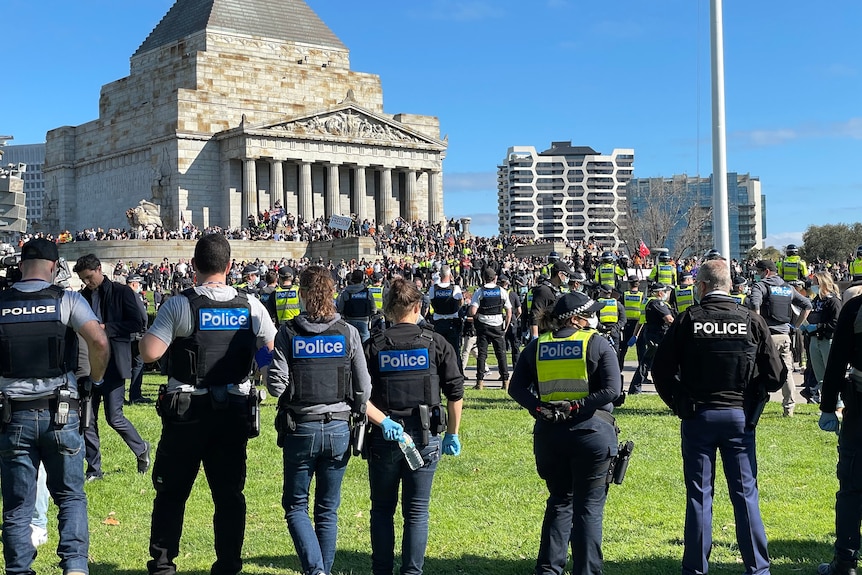 A ring of policemen and women stand 