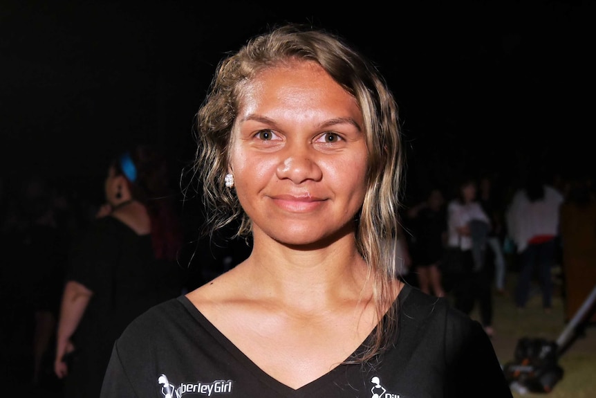 A young woman with a bright face and her hair pulled back gazes directly at the camera.