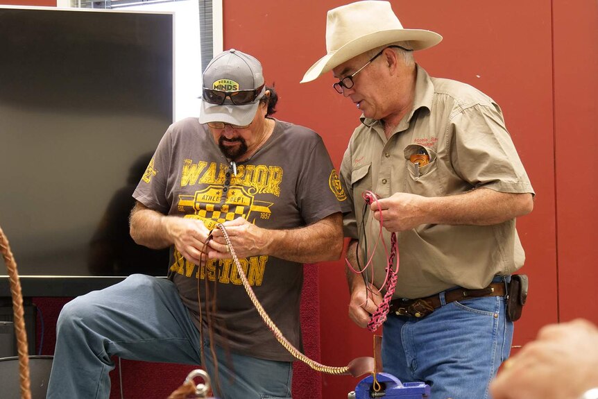 Two men leather working creating a whip and a hat band
