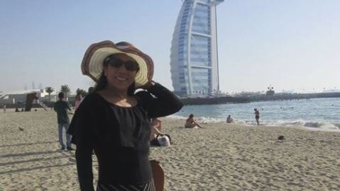Marilou Danley holds her hat as she stands in front of the Burj al arab in dubai