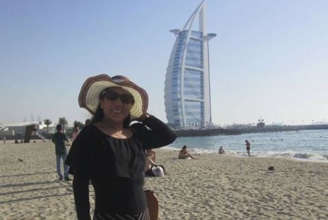 Marilou Danley holds her hat as she stands in front of the Burj al arab in dubai