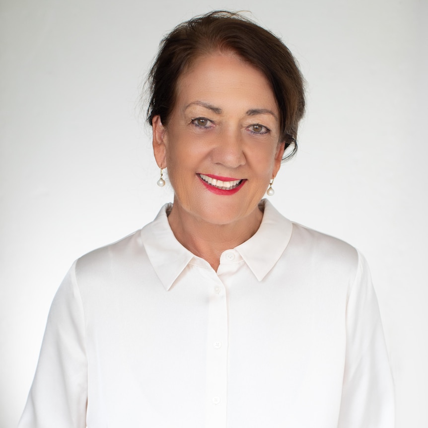 woman in white collared shirt, smiling