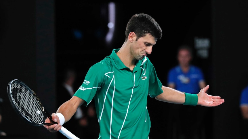 A tennis player spreads his arms wide after losing a point.