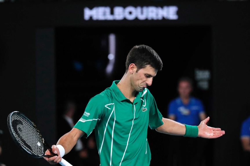 A tennis player spreads his arms wide after losing a point.