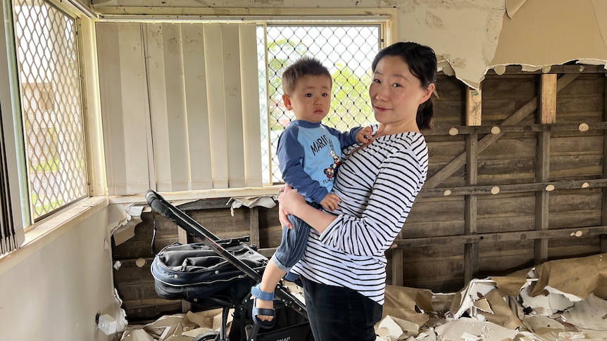 Sandy Xia and son Nulan in their flooded home.
