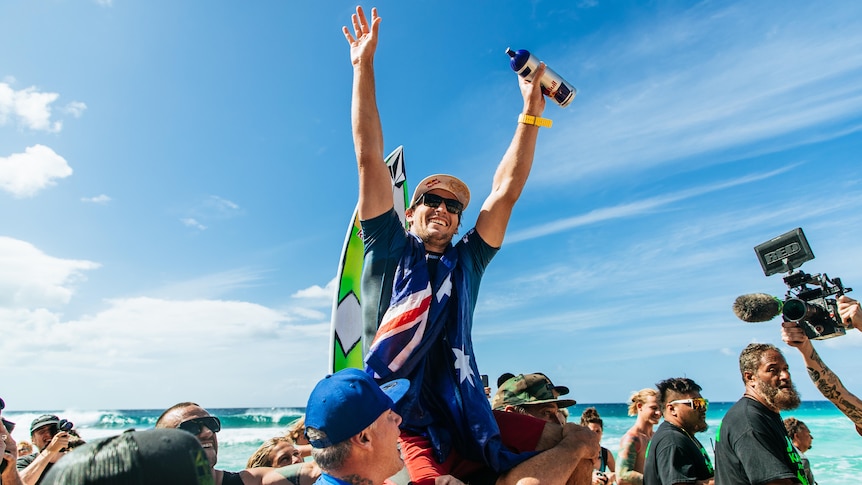 An Australian male surfer celebrates winning Pipeline event in Hawaii.