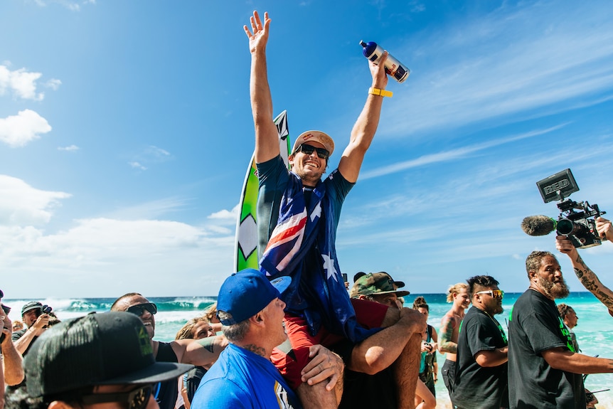 An Australian male surfer celebrates winning Pipeline event in Hawaii.