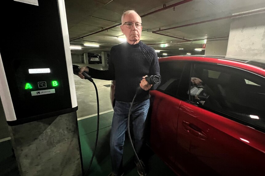 a man at a charging station with his electric car