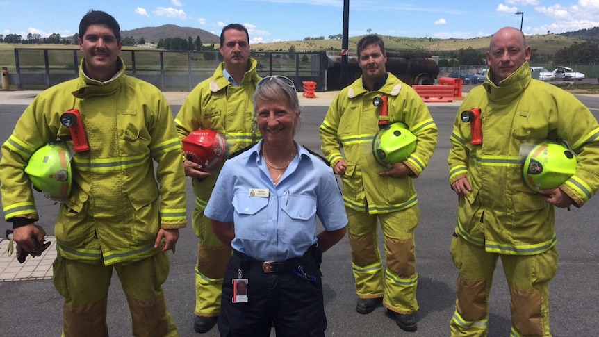 Station officer Gina Kikos, flanked by four male fire fighters