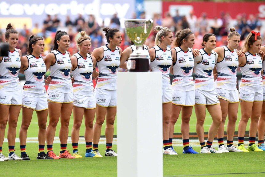 Adelaide Crows line up behind the AFLW premiership trophy