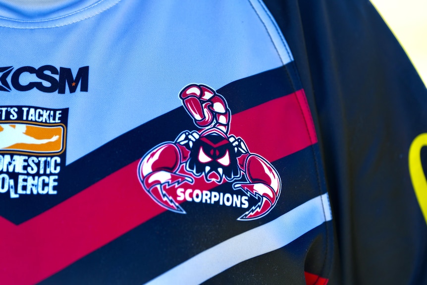 A logo of a scorpion coloured in red, black and white on a jersey