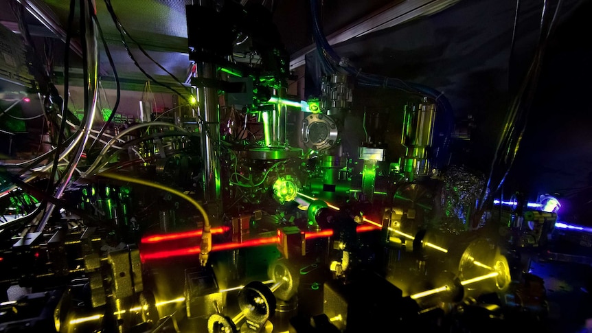 Lasers shining on a clock in a lab.