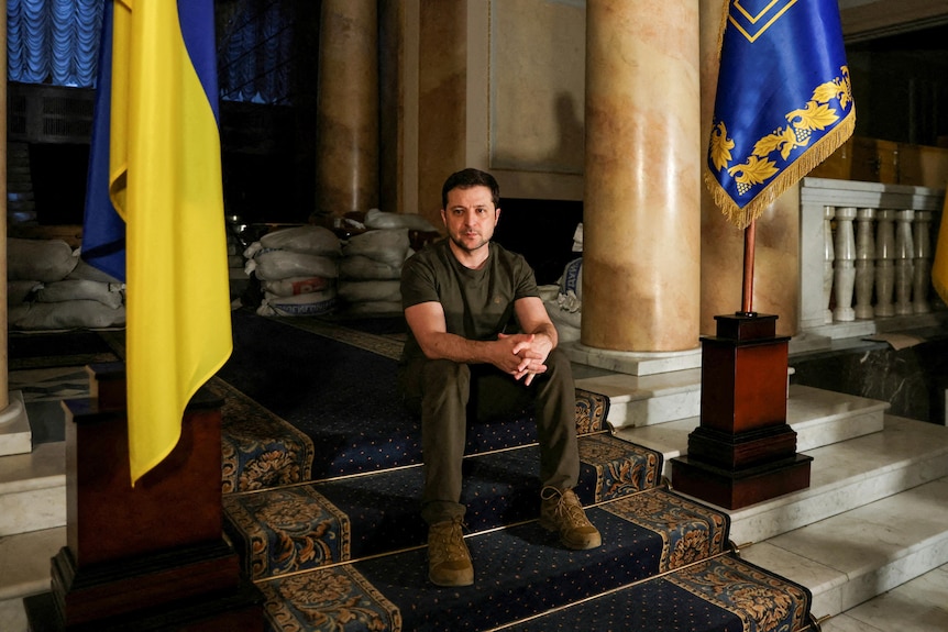 Ukraine President Volodymyr Zelenskyy sits on steps