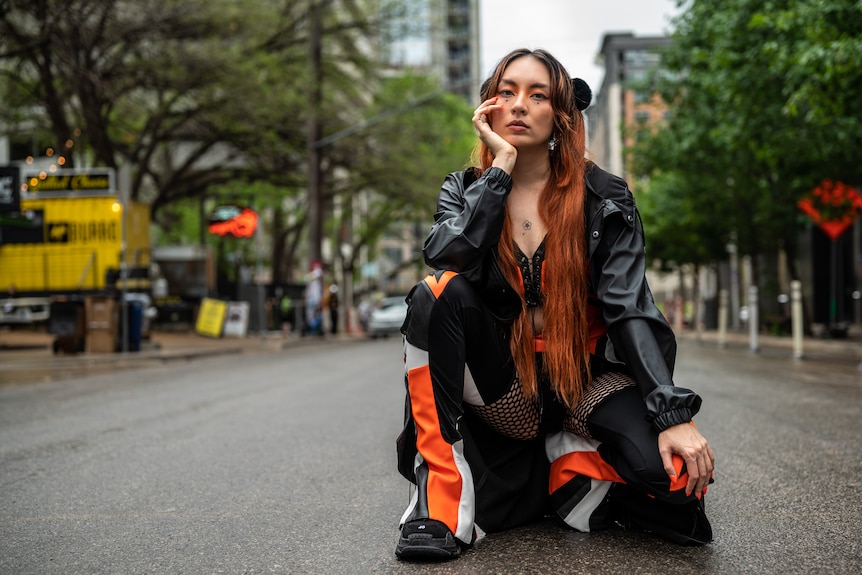 Jaguar Jonze, a Taiwanese Australian woman kneels down in middle of the road