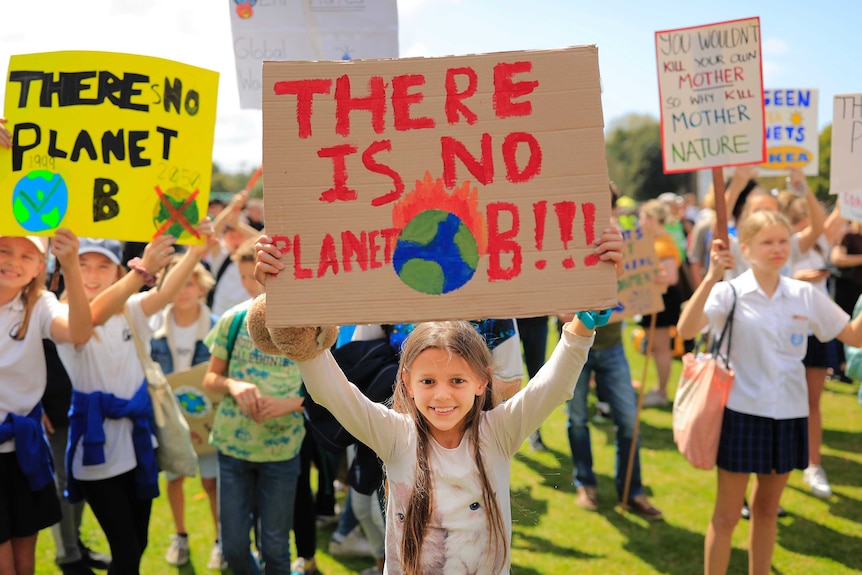 A girl holds up a sign reading "there is no planet B" during a school climate strike in Sydney.