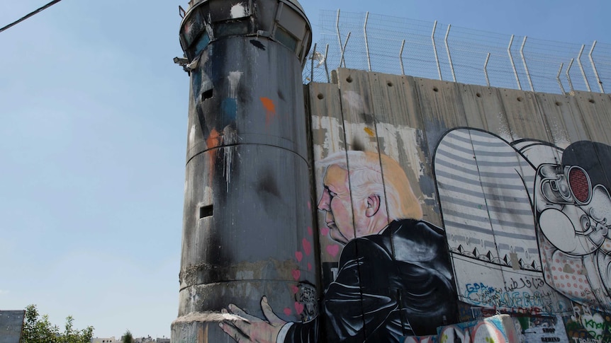 A mural of Donald Trump kissing an Israeli army watchtower, part of Israel's West Bank separation barrier.